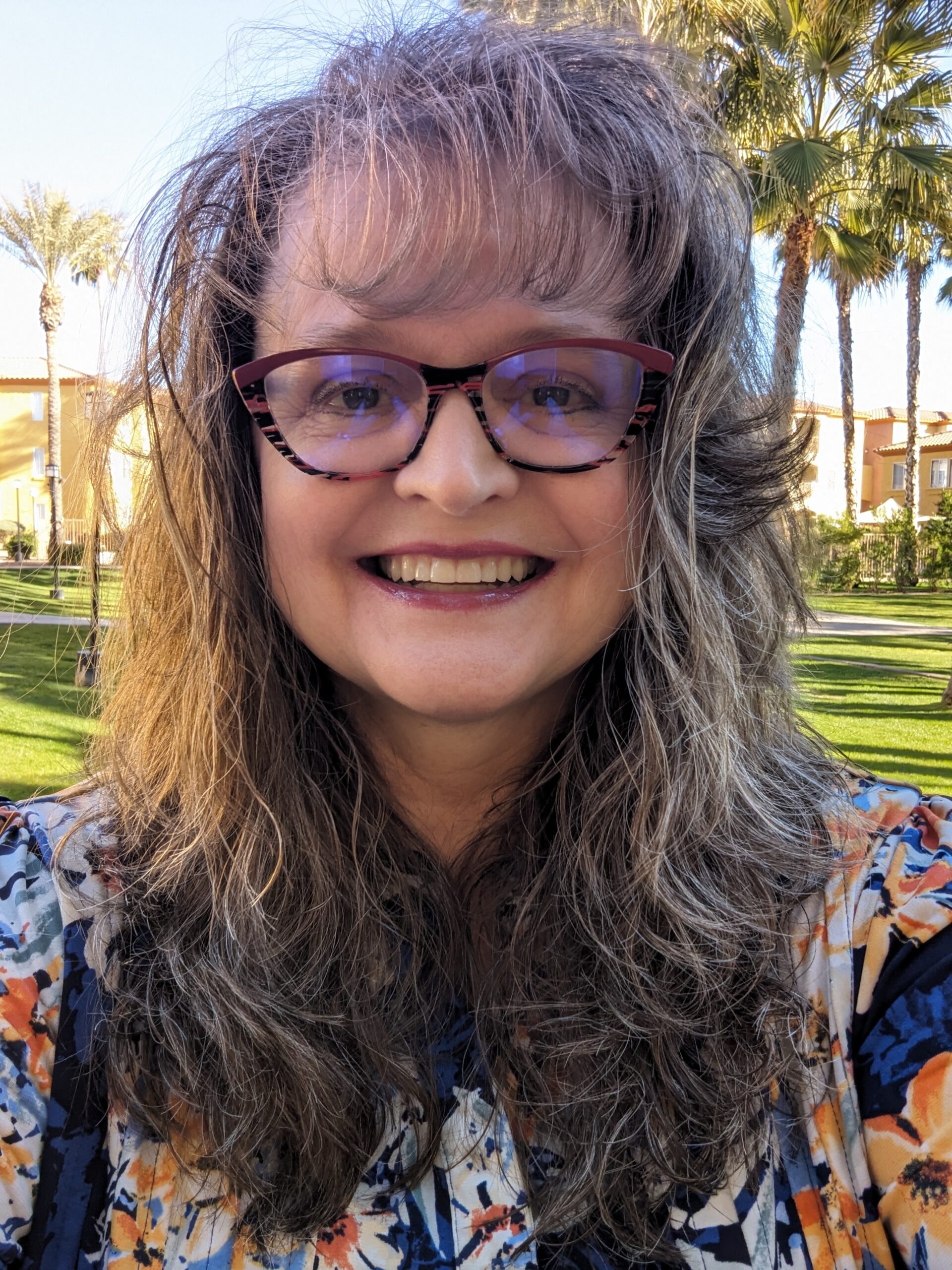 Profile picture of Twyla Hornick with a green grass and palm trees in the background.